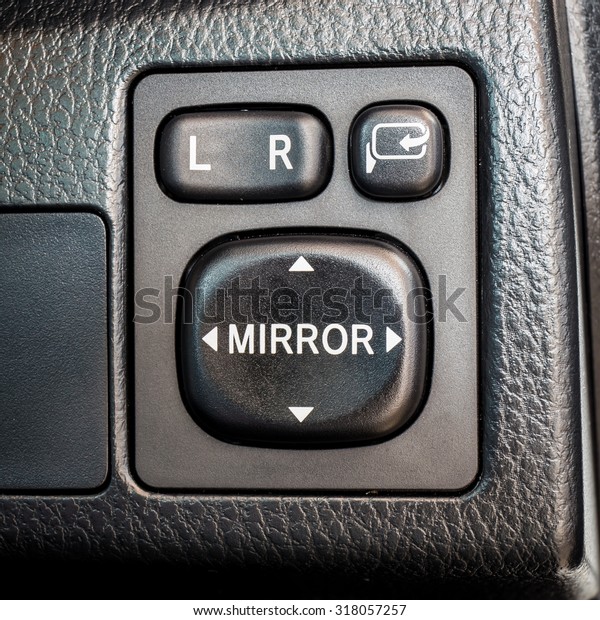 Switch\
button adjust or controls side mirrors in a\
car