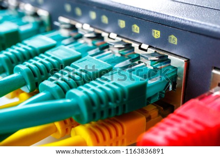 switch for Internet access in it are inserted different color cables patchcords, glowing switch ports