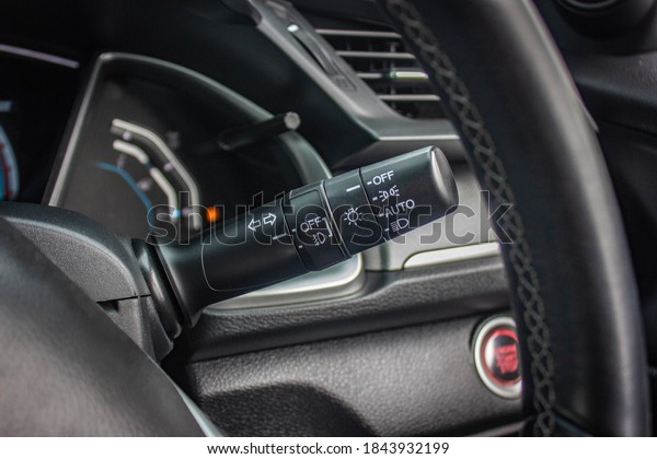 Switch off lights in a car.\
close-up Car integrated turning indicator with headlight switch\
toggle.