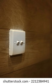 A Switched Off White Light Switch On Wooden Wall Inside Hotel