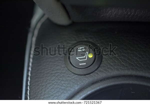 Switcher of car\'s heated seats. Black button with\
pictogram and green diode\
lamp.