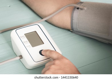 switching on the blood pressure monitor, tinted image, selective focus, wooden background - Shutterstock ID 1441150640