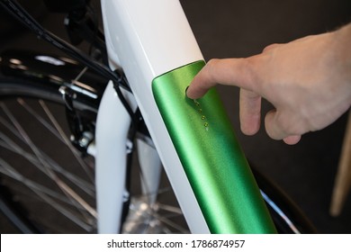 Switching On Eletric Bicycle. Male Hand Pressing Button On Ebike Battery.