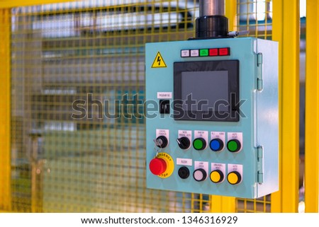 Swith button on automation machine control panel with background yellow safety fence