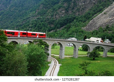Switzerland, July 2012: Swiss Red Train Bernina Express pass on Brusio Viaduct, Italy & Switzerland