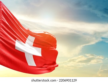 Switzerland national flag waving in beautiful sky.
