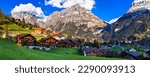 Switzerland nature and travel. Alpine scenery. Scenic traditional mountain village Grindelwald surrounded by snow peaks of Alps. Popular tourist destination and ski resort
