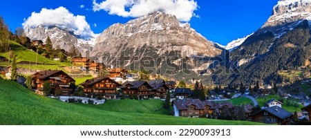 Switzerland nature and travel. Alpine scenery. Scenic traditional mountain village Grindelwald surrounded by snow peaks of Alps. Popular tourist destination and ski resort