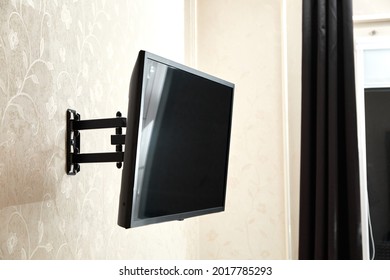 Swivel TV bracket LED display. Side view. X-shaped red fasteners. Black color. Multiplanar. Hangs on a wall. Reliable and comfortable fastening. Childproof and rollover protection. Metallic equipment. - Shutterstock ID 2017785293