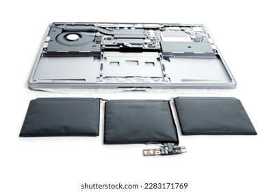 Swollen laptop battery placed next to a disassembled laptop isolated on white background. Overcharging and proper battery maintenance concept.