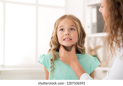 Swollen Tonsils. Female Doctor Examining Girl Tonsils In Hospital, Copy Space