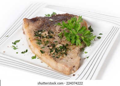 Swordfish Steak Cooked On A Plate With A Parsley And Garlic Butter Sauce