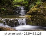 The Sychryd Cascades or Sgydau Sychryd Falls with wooden bridge in the Waterfall Country near the Dinas Rock, Pontneddfechan, Brecon Beacons National Park, South Wales, UK. Long exposure water.