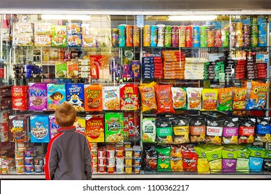 Sydney, AU - MAY 20, 2018: A little boy is looking at the colorful snacks shelf in a supermarket.