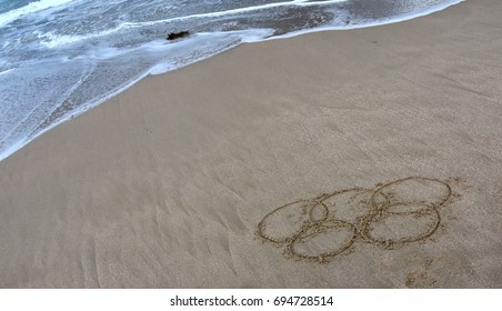 Sydney, Australia - Aug 7, 2016. Wave Approaches Olympic Rings Drawn In The Sand. Summer Olympic Games.