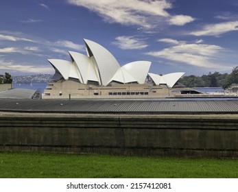 SYDNEY, AUSTRALIA - Dec 09, 2021: A Beautiful Shot Of The Sydney Opera House As Seen From A Far Green Grassland Point Under The Clear Blue Sky, Sydney, Australia 