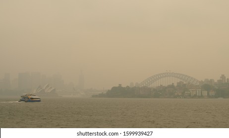 SYDNEY, AUSTRALIA. DECEMBER 10 2019. Bush Fire Smoke Over Sydney Harbour Bridge, A Ferry Traveling To Circular Quay..