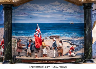 Sydney, Australia - December 11, 2009: Inside Queen Victoria Building Shopping Mall. Closeup Of Captain-Cook-landing Painting And Puppets Set In Giant Clock Contraption. Blue Sky, Beige Sand, And Peop