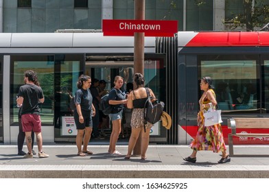 Sydney, Australia - January 26, 2020: People Using Tap On Tap Off Ticket Automation Machine At Chinatown Light Rail Station With Red Tramway Car On The Backgorund 