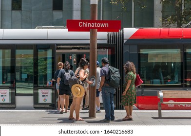 Sydney, Australia - January 26, 2020: People Using Opal Tap On Tap Off Ticket Automation Machine At Chinatown Light Rail Station With Red Tramway Car On The Backgorund