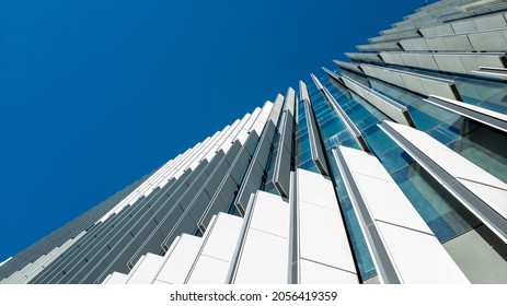 Sydney, Australia – Jul 18, 2019: Upward View From Street Level Of A Tall Modern Office Building Exterior. Against A Blue Sky. Adjustable External Slats To Control Incoming Natural Sunlight.