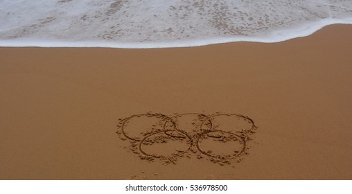 Sydney, Australia - Jul 31, 2016. Wave Approaches Olympic Rings Drawn In The Sand. Summer Olympic Games.