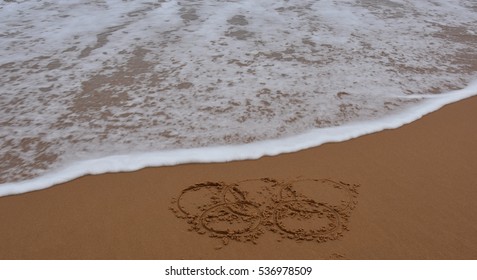 Sydney, Australia - Jul 31, 2016. Wave Approaches Olympic Rings Drawn In The Sand. Summer Olympic Games.