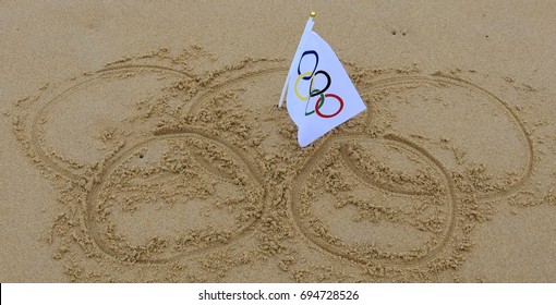 Sydney, Australia - Jul 31, 2016. Olympic Rings Drawn In The Sand And Olympic Flag In The Centre. Summer Olympic Games