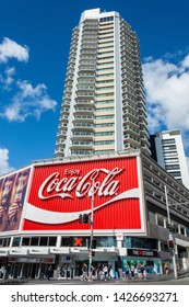 Sydney, Australia - March 10, 2017. The Coca-Cola Billboard In Kings Cross, Sydney, With Commercial Properties And People, At Daytime.