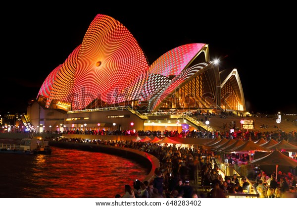 SYDNEY, AUSTRALIA - MAY 26, 2017; Opening Night of\
Vivid Sydney, the forecourt bars and restaurants full of tourists\
and locals.  Sydney Opera House alive vibrant moving designs of\
Vivid Sydney