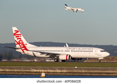 Sydney, Australia - May 5, 2014: Virgin Australia Airlines Boeing 737-800 Aircraft At Sydney Airport With A REX Saab 340 Landing Behind. 