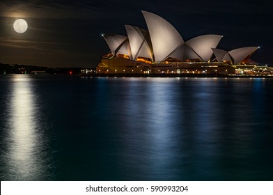 Sydney, Australia - November 15, 2016: The Bright Supermoon And The Reflections In The Water Make The Gorgeous Architecture Of Sydney Opera House Look Even More Majestic.Artistic Concept. 