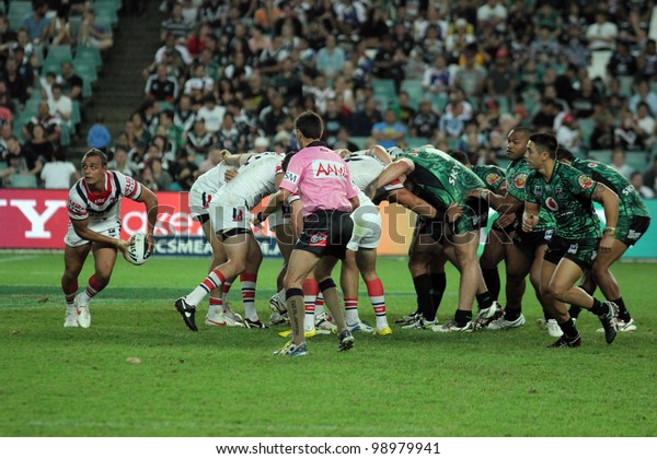SYDNEY - MARCH 31: NRL The Sydney Roosters and\
the New Zealand Warriors go head to head in a Scrum at the Sydney\
football Stadium. A roosters player receives the ball. March 31,\
2012 Sydney Australia