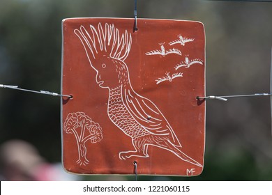 Sydney, New South Wales / Australia - October 27 2018: P\close Up Of Plate With Aboriginal Art Showing Cockatoo During Sculpture By The Sea Exhibition With Blurred Green Background