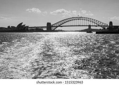 Sydney, NSW Australia - 10/23/2018: The Opera House And Harbour Bridge Silhouettes From A Ferry Heading To Manly In The Late Afternoon And Leaving A Neat Wake Behind