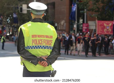 Sydney, NSW Australia - April 25 2021: Anzac Day March. Policeman In A High Vis Vest Watching The March And Holding A Radio