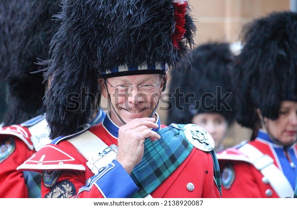 Sydney, NSW Australia - April 25 2021: Anzac Day\
March. A smiling member of the NSW Police Pipe Band wearing a\
feather bonnet and\
uniform.