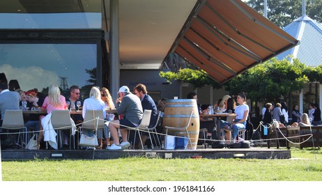 Sydney, NSW Australia - April 6 2021: People Seated And Enjoying Lunch On The Verandah Of A Busy Restaurant, Centennial Homestead. Dining Outdoors. Also Pictured Is Are Brown Retractable Awnings. 