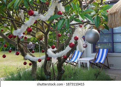 Sydney, NSW, Australia, December 13, 2020. Australian Christmas Scene With A Festive Tropical Tree Decorated With Baubles