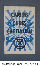 Sydney, NSW  Australia - January 4 2021: Poster on wall reading "Caring cures Capitalism"