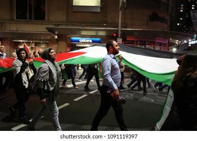 SYDNEY, NSW / AUSTRALIA - May 15, 2018: Protestors Carry A Flag Through The City Centre At A Demonstration Held To Mark 70 Years Since The Palestinian Exodus (Nakba) In 1948.