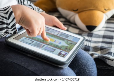 Sydney NSW Australia May 26th 2019 - Child sitting on the lounge and playing tablet