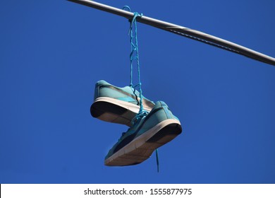 Sydney, NSW / Australia - November 4 2019: Shoes On A Wire: Untangling An Urban Myth. Pictured Is Pair Blue Runners Hanging From Power Lines In The Inner West.