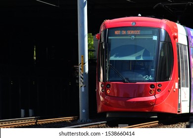 Sydney, NSW / Australia - October 10 2019: Play It Safe Around Sydney Light Rail. Pictured Is A Red Light Rail Train Coming Out Of A Tunnel, It's Digital Signage Reads 