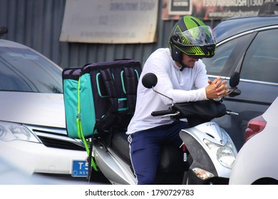 Sydney, NSW / Australia - October 20 2019: Food Delivery Drivers Struggle To Make Ends Meet In Gig Economy. Pictured Is A Man On A Scooter. The Food Delivery Back Pack Is Strapped To The Scooter.