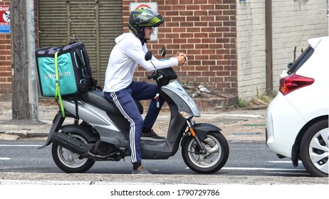 Sydney, NSW / Australia - October 20 2019: Food Delivery Drivers Struggle To Make Ends Meet In Gig Economy. Food Courier In Traffic On A Motor Scooter. The Back Pack Is Strapped To The Scooter.