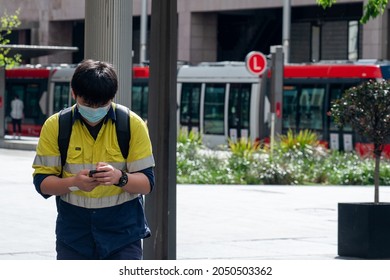 Sydney NSW Australia September 2021: Person In Work Uniform On His Phone With Face Mask On Due To Covid 19