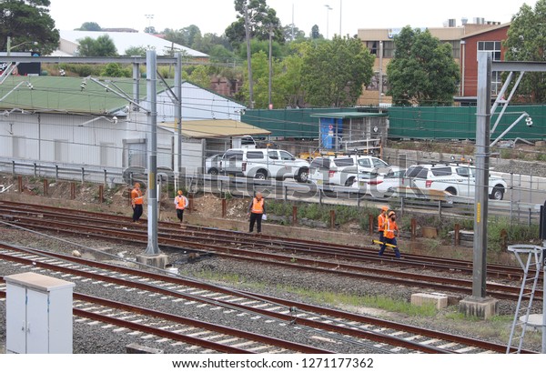 Sydney, NSW /\
Country - January 12 2018: Trains delayed due to emergency track\
work. Multiple workman inspecting the tracks with \