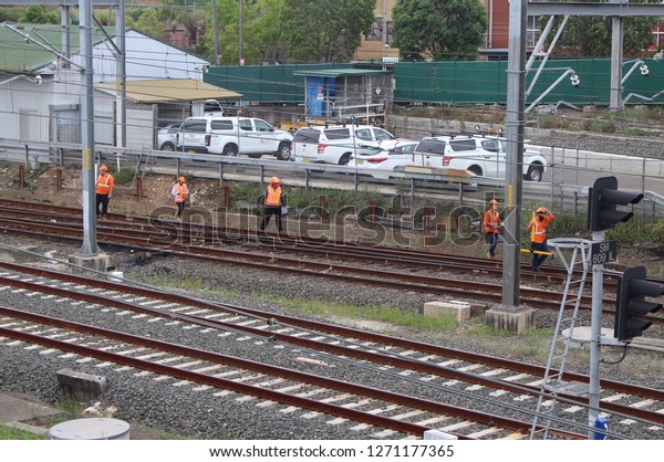 Sydney, NSW /\
Country - January 12 2018: Trains delayed due to emergency track\
work. Multiple workman inspecting the tracks with \
