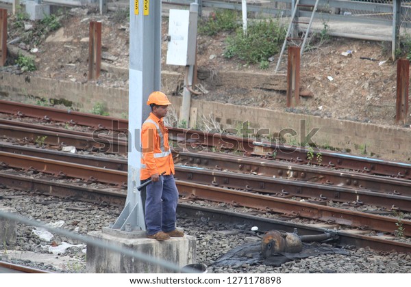 Sydney, NSW Country - January 12 2018:\
Trains delayed due to emergency track work. Rail worker looking out\
for train holding warning horn in his\
hand.